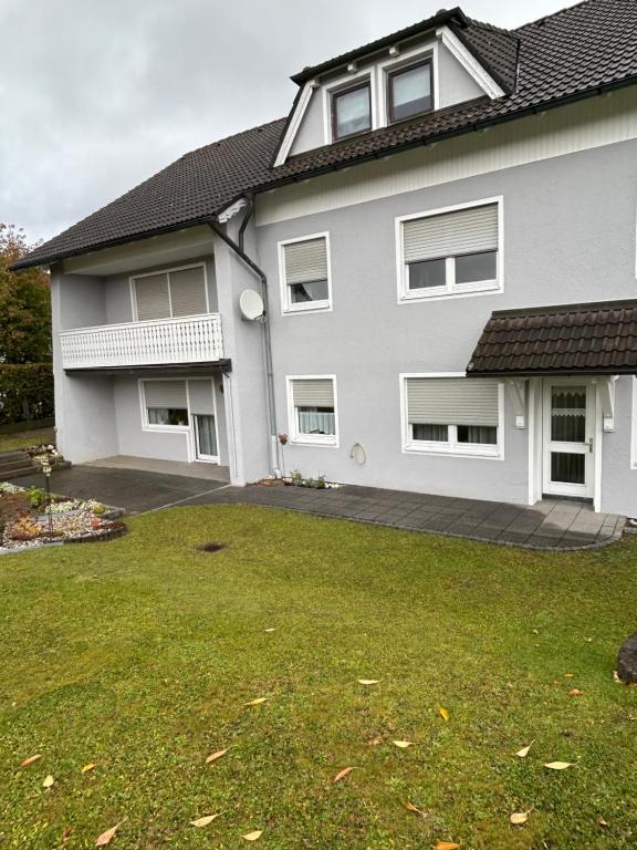 ein weißes Haus mit Rasen davor in der Unterkunft Ferienwohnunghaus Kellermann in Moosbach