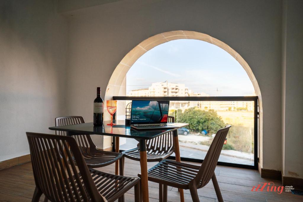 d'une salle à manger avec une table, des chaises et une fenêtre. dans l'établissement Music, F1 & Fashion Fun in this holiday home, à San Pawl il-Baħar
