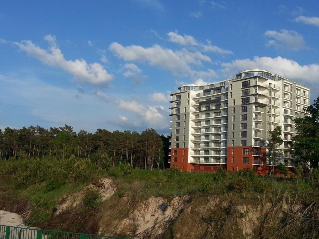 a tall white building on top of a hill at Porta Mare Apartments LuxView II in Dziwnówek