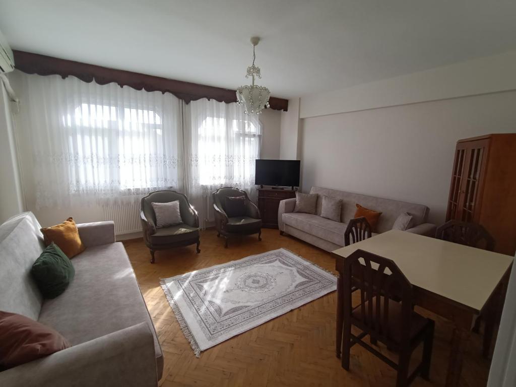 uma sala de estar com um sofá, uma mesa e cadeiras em Hatice em Istambul