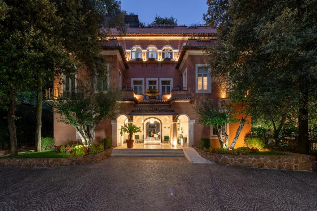 a large house with a driveway in front of it at Hotel Principe Torlonia in Rome