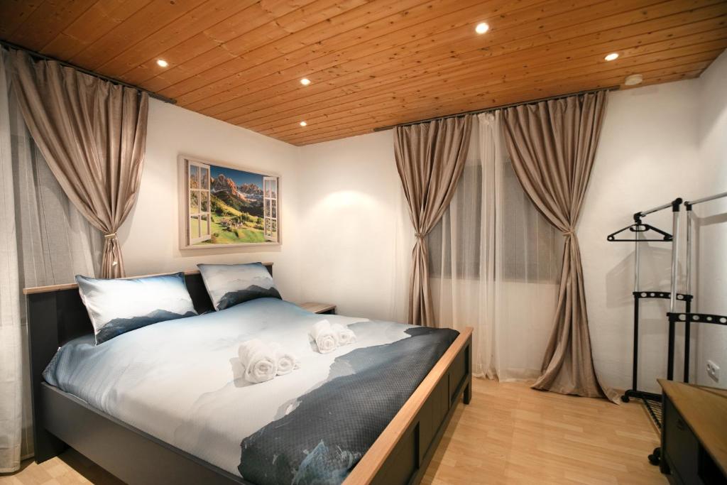 una camera da letto con letto con lenzuola e tende bianche di Alpina Haus a Oberammergau