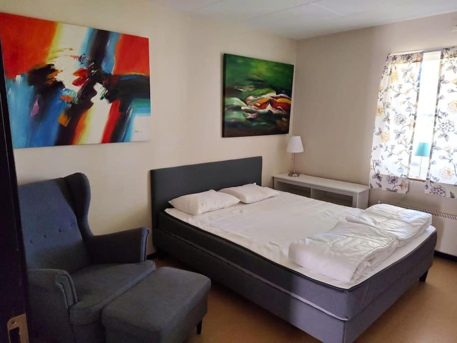 a bedroom with a bed and a chair at Apartment in Lekvattnet in Torsby