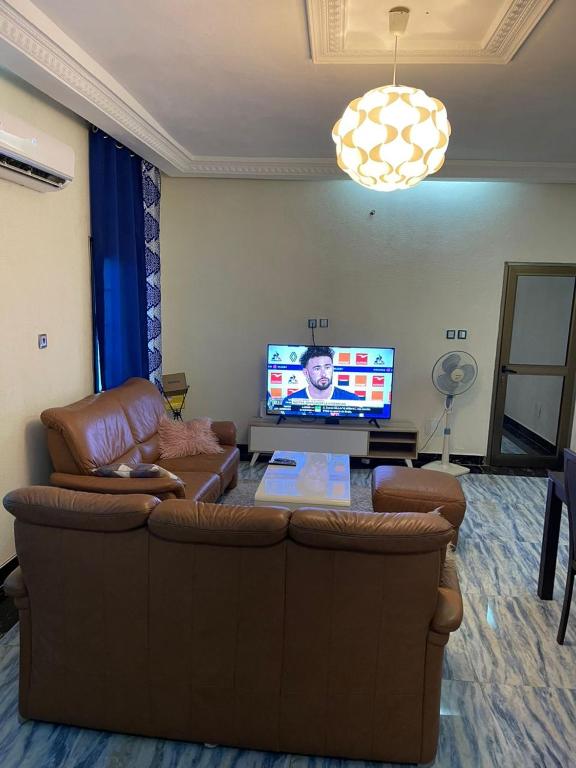 sala de estar con sofá y TV de pantalla plana en Appartement a hedzranawoe, en Lomé