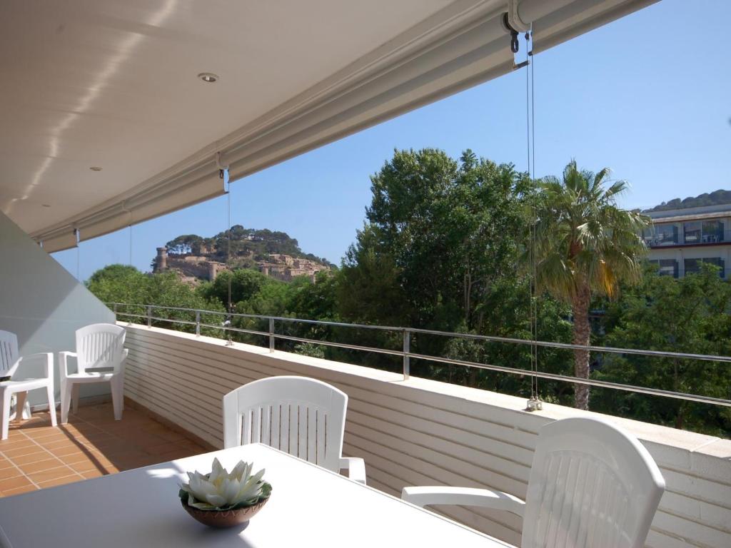 d'un balcon avec des chaises blanches et une vue sur un bâtiment. dans l'établissement Lets Holidays Tossa de Mar Ancora, à Tossa de Mar