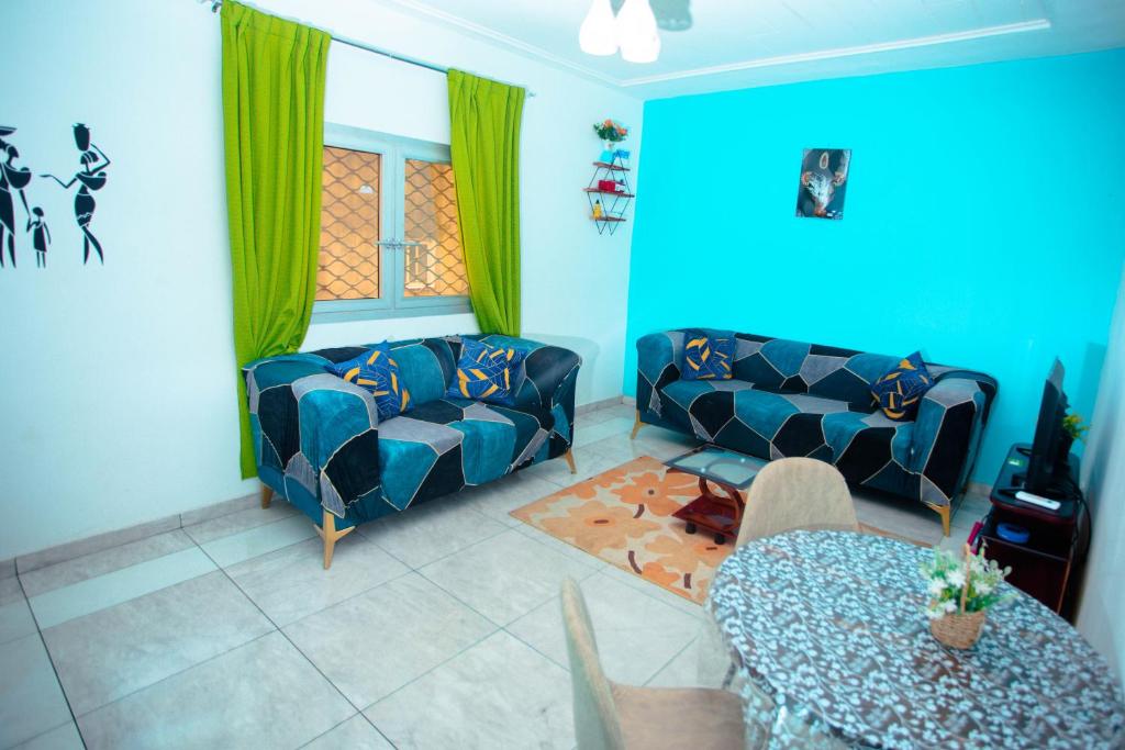 a living room with a couch and a table at Appartement Meublé Bonamoussadi Douala in Deido