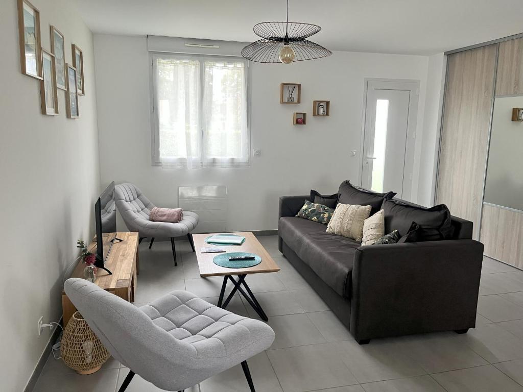 uma sala de estar com um sofá e uma mesa em Maison 4/6 personnes à Bayeux em Bayeux