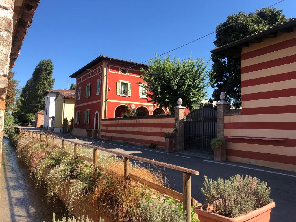 un bâtiment rouge au milieu d'une rue dans l'établissement B&B Villa la Canonica a Padernello, 