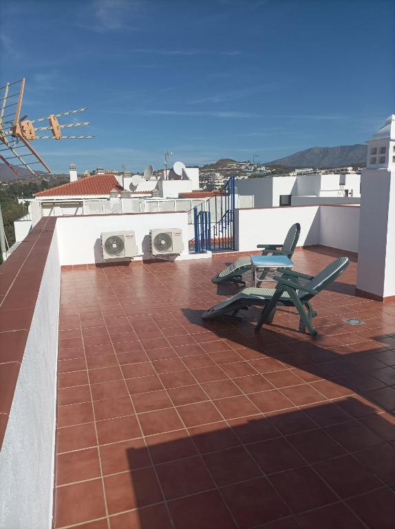 a balcony with a bench and two washing machines on a roof at Ático cala de Mijas in Mijas