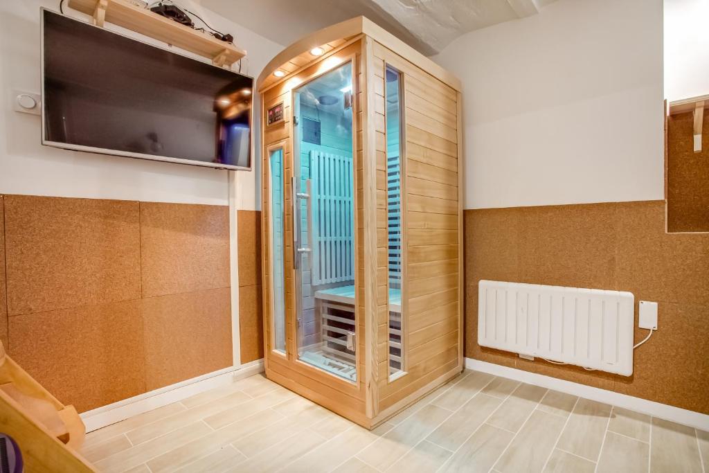 Cette chambre dispose d'une fenêtre, d'un radiateur et d'une télévision. dans l'établissement Tiny Duplex with Sauna in the 11, à Paris