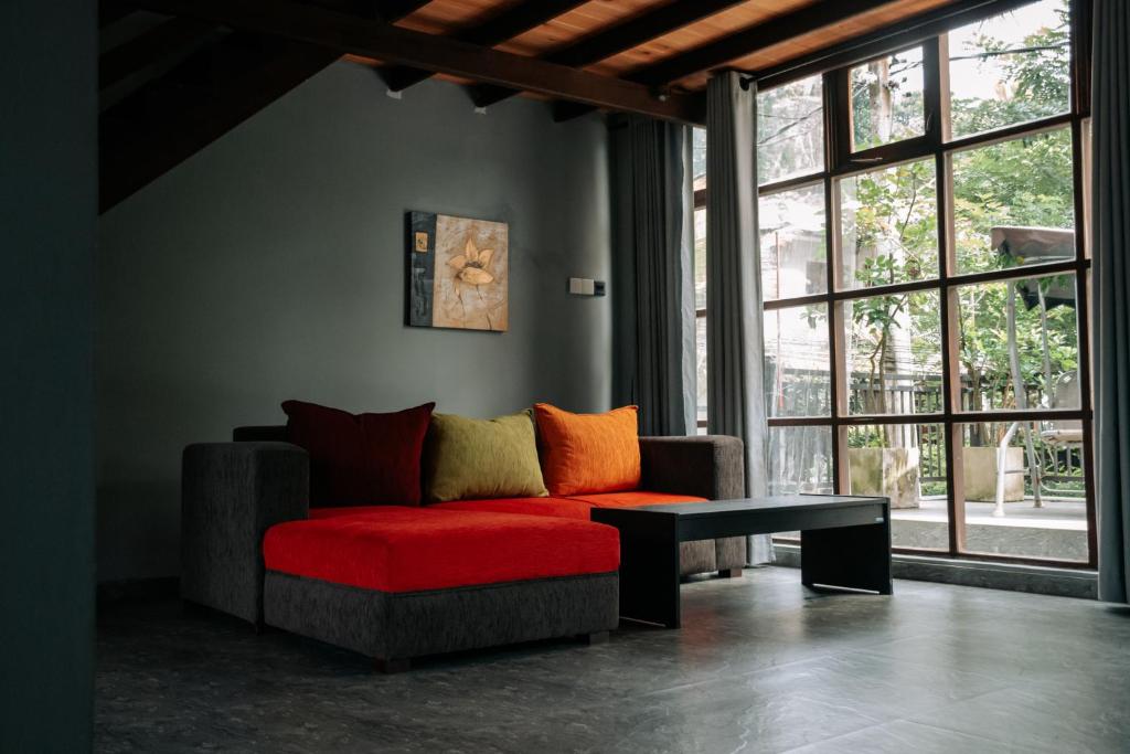 a living room with a red couch and a table at Amanzi Residence in Kandy