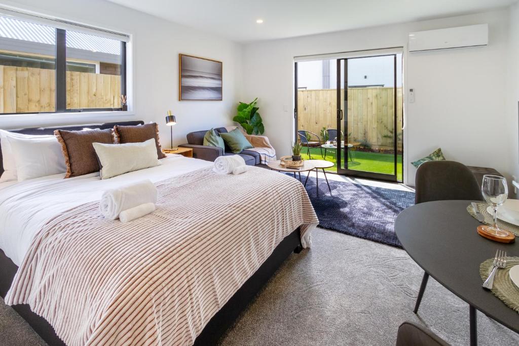 a bedroom with a large bed and a living room at Serenity Getaway in Christchurch