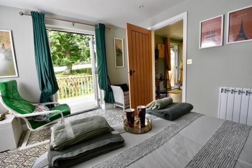 een slaapkamer met een groot bed en een raam bij Sheepwash Farm Rural Spa Retreat Cottages in Ticehurst