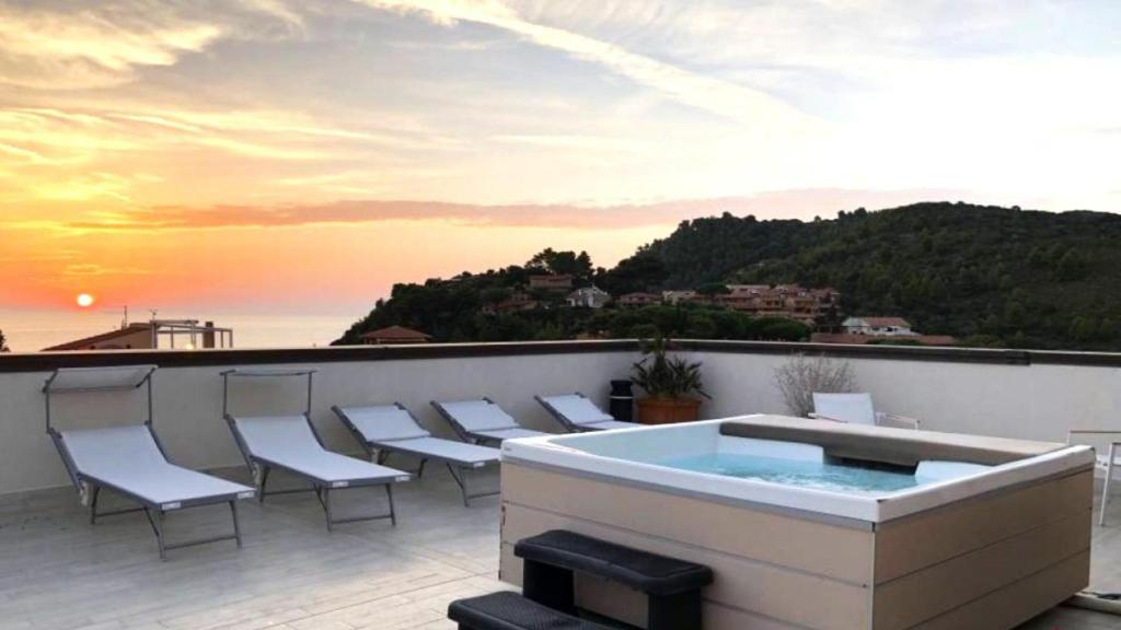 a hot tub on a balcony with a view of the ocean at Hotel Il Telamonio in Talamone