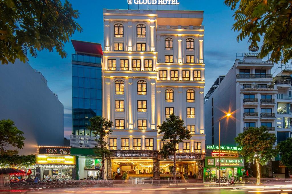 a tall white building with lights on at Gloud Hotel in Hanoi