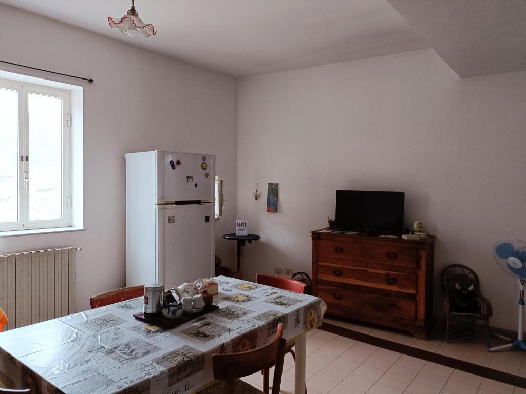 eine Küche mit einem Tisch und einem weißen Kühlschrank in der Unterkunft Casa Vacanza Vico Medica in Modica