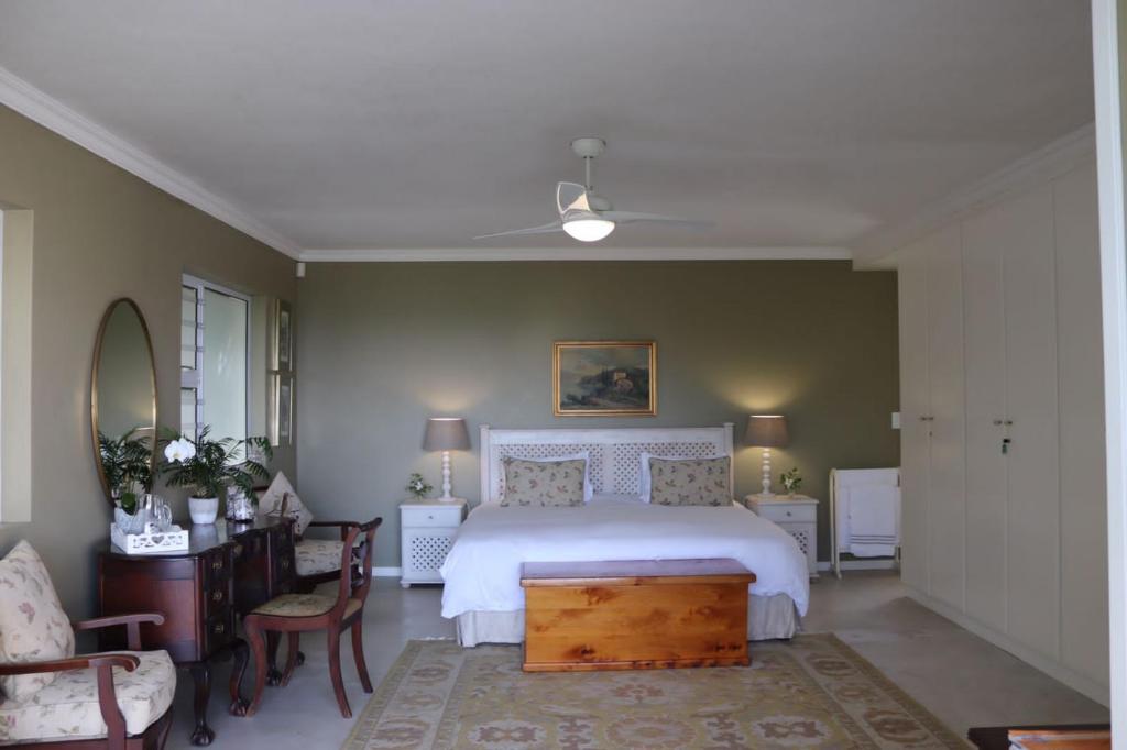 拉姆斯蓋特的住宿－Bo-Yoga，卧室配有白色的床和桌椅