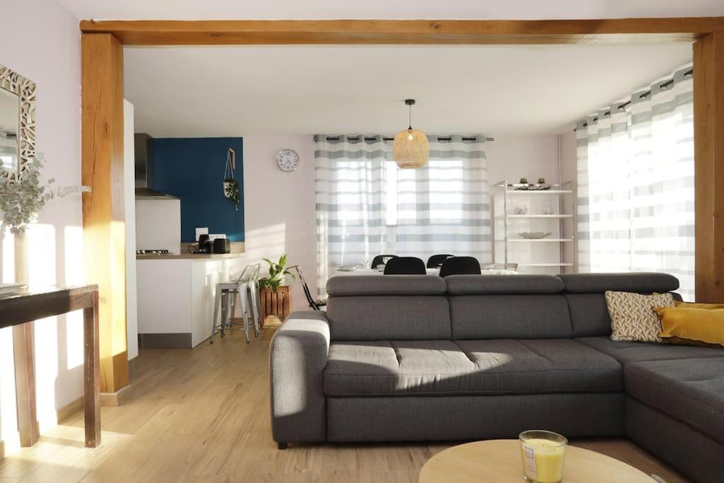 uma sala de estar com um sofá cinzento e uma mesa em Maison Le Chapitre by La Boîte En Plus em Senlis