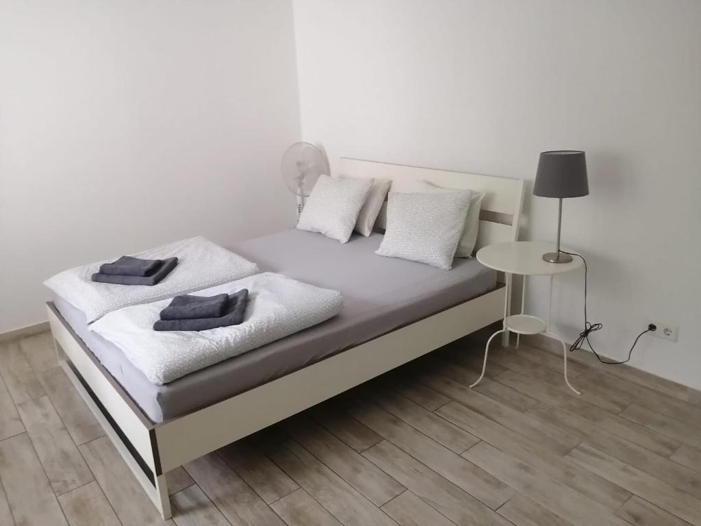 ein weißes Bett mit weißen Kissen und einem Tisch in der Unterkunft Excellent Apartment M&L in Wien