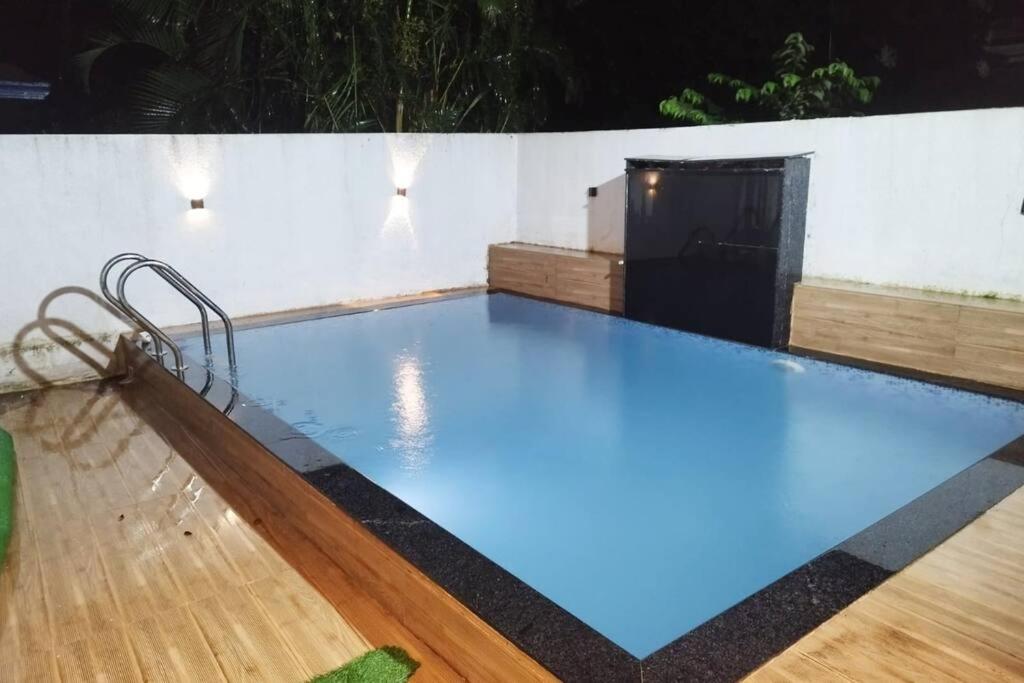 a swimming pool with blue water in a building at Lonavala Villa in Lonavala