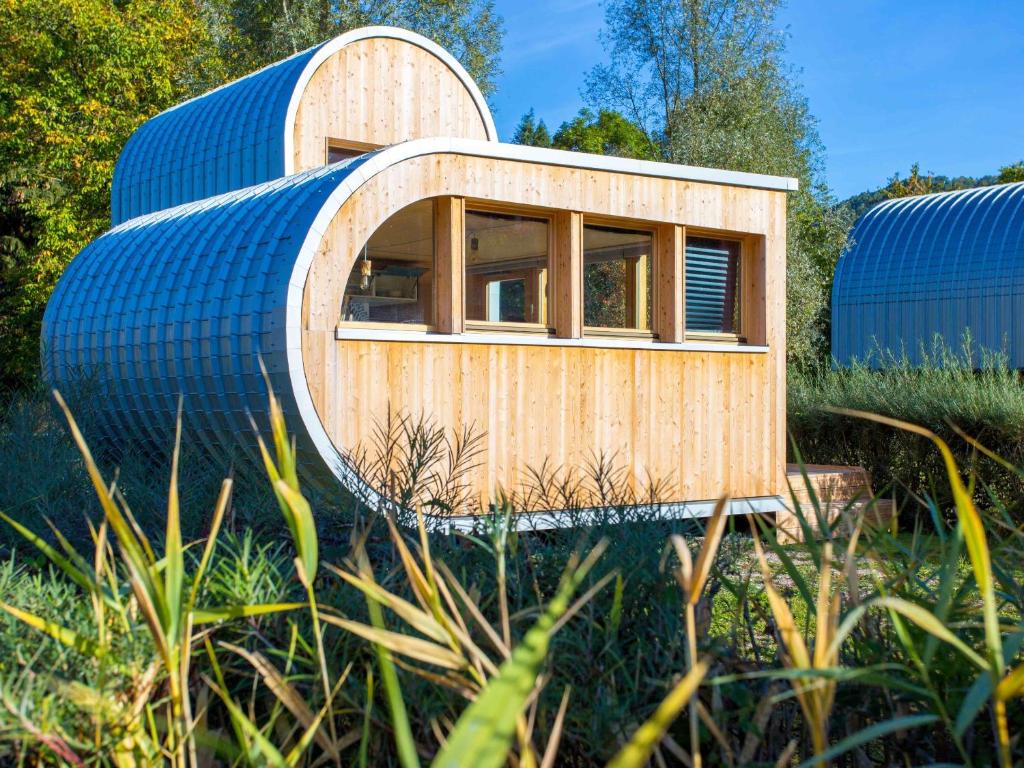 une petite maison en bois avec un toit bleu dans l'établissement L'Oasis des Coccinelles, à Sainte-Croix-aux-Mines
