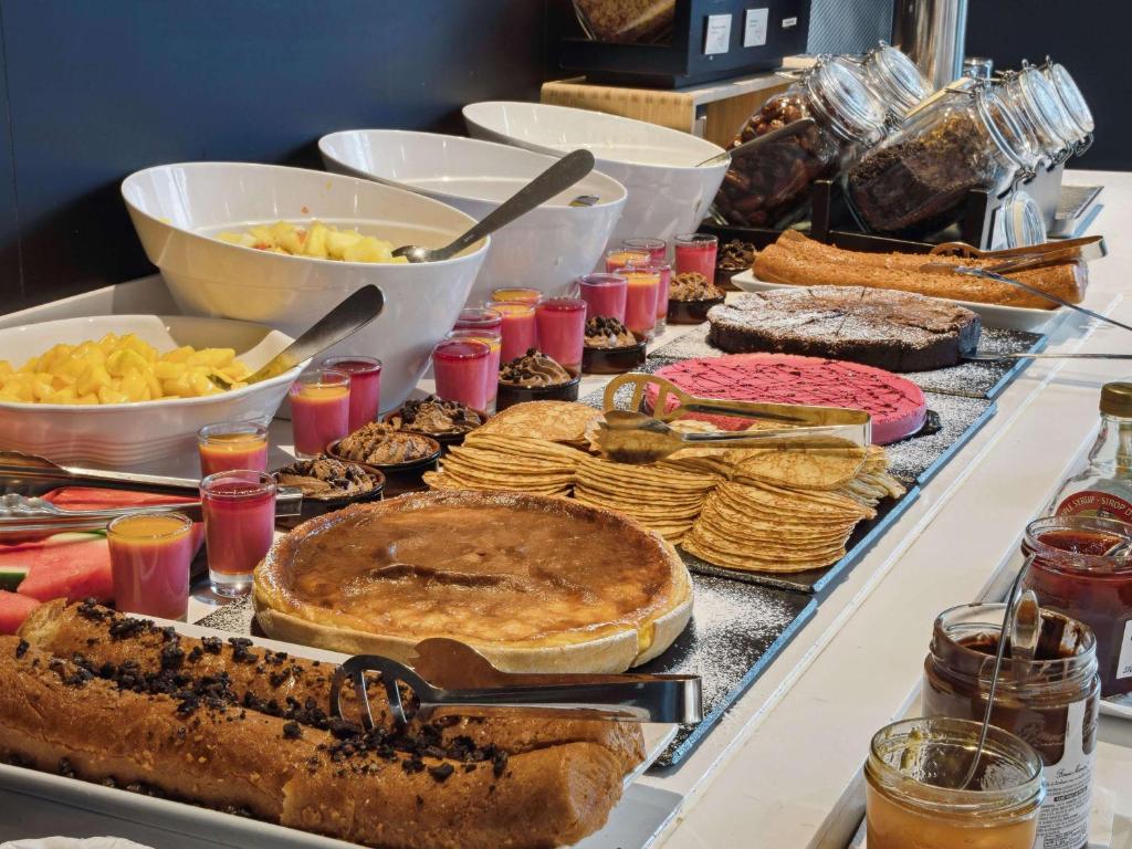 a buffet with many different types of food on a table at ibis Styles Paris Charles de Gaulle Airport in Roissy-en-France