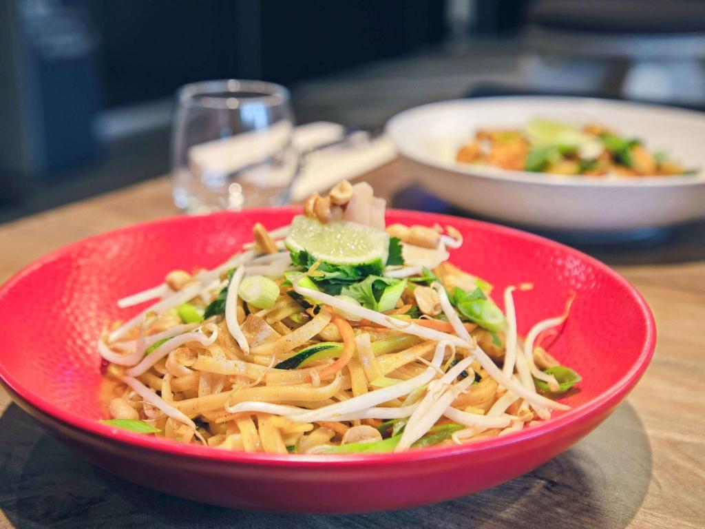 a red bowl of food on a table at ibis Styles Paris Charles de Gaulle Airport in Roissy-en-France