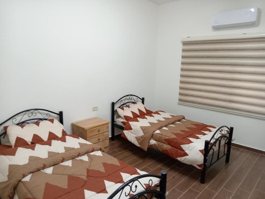 Duas camas sentadas uma ao lado da outra num quarto em EMILE ALTWAL em Madaba