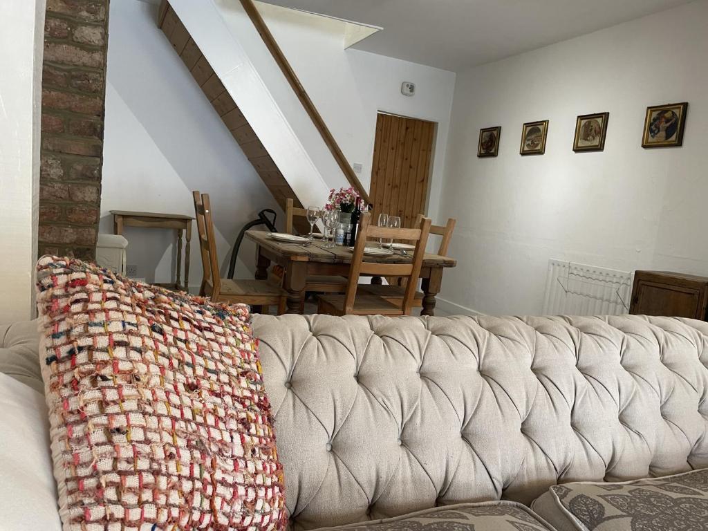 um sofá sentado numa sala de estar com uma mesa em Poplar Cottage Farnborough Kent em Orpington