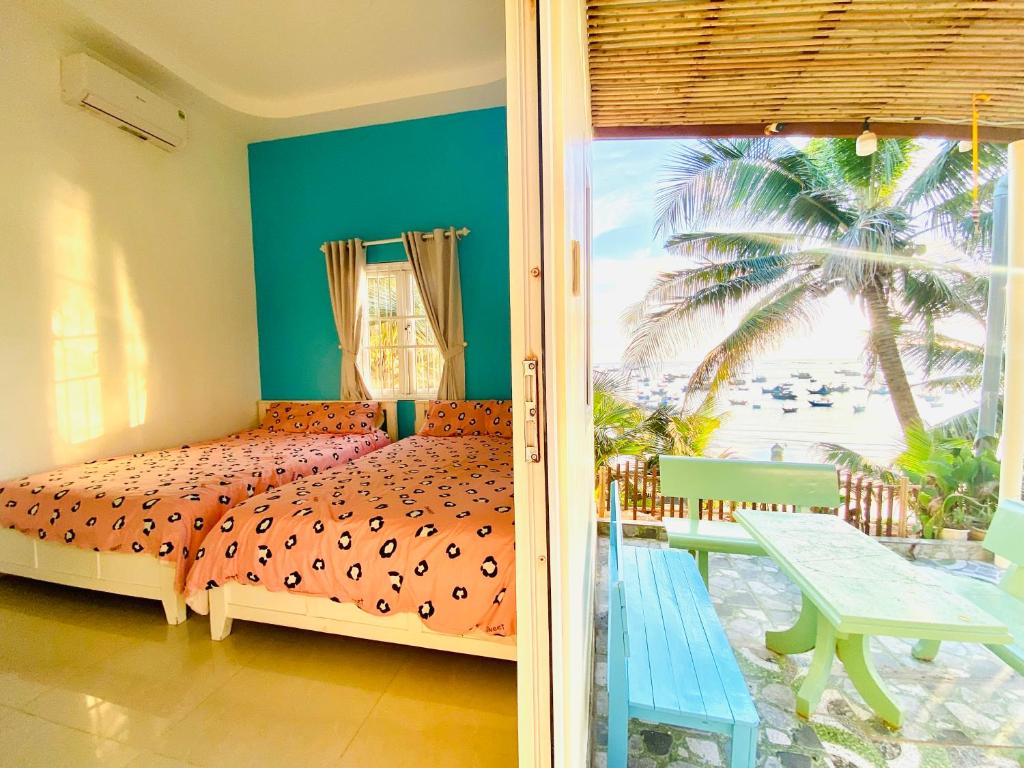 una camera con letto e vista sulla spiaggia di Homestay BONO Mũi Né a Phan Thiet