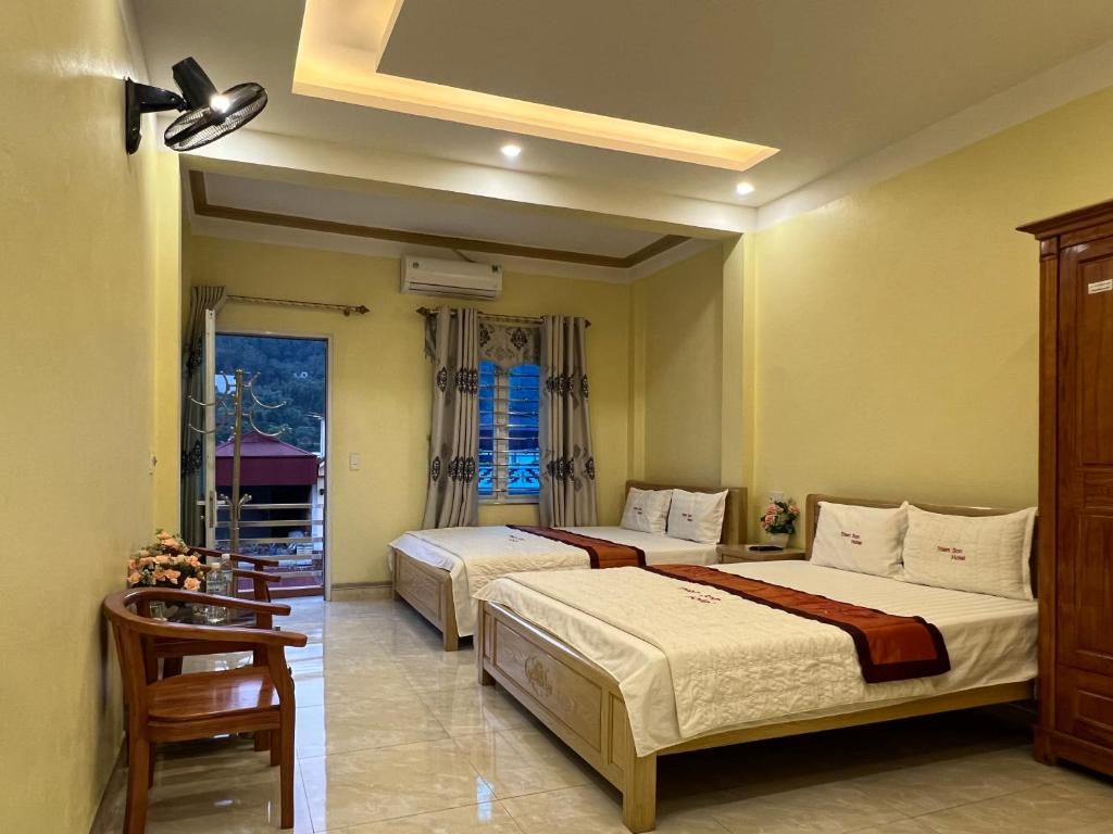 - une chambre avec 2 lits et une fenêtre dans l'établissement Thien Son Guesthouse, à Ha Giang