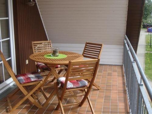 einen Holztisch und Stühle auf einer Veranda in der Unterkunft Ostseespaß in Elmenhorst