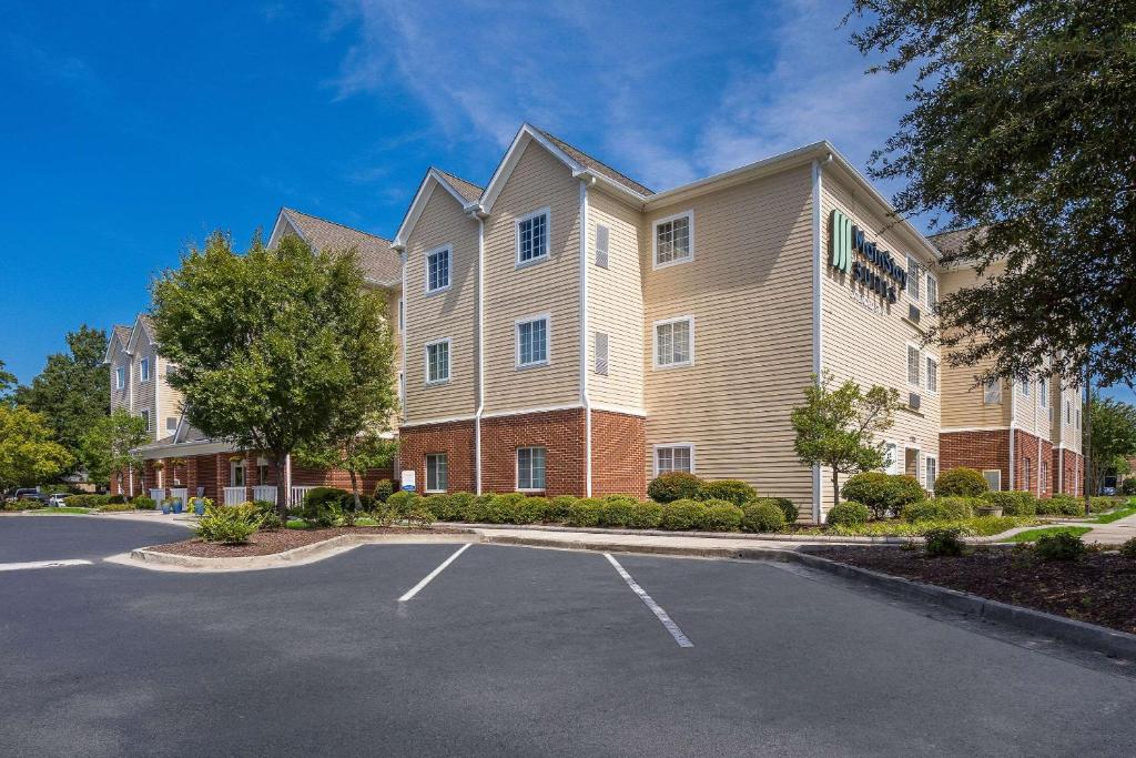 a large building with a parking lot in front of it at MainStay Suites Wilmington in Wilmington