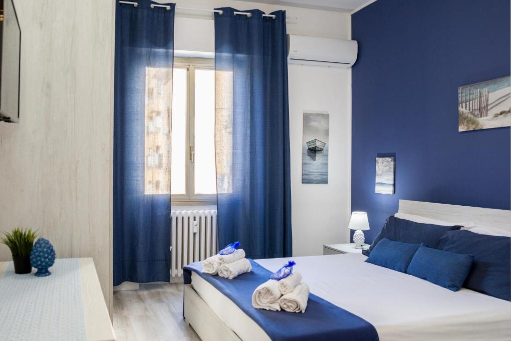 ein blaues Schlafzimmer mit einem Bett mit Handtüchern darauf in der Unterkunft Riva Serena in Lido di Ostia