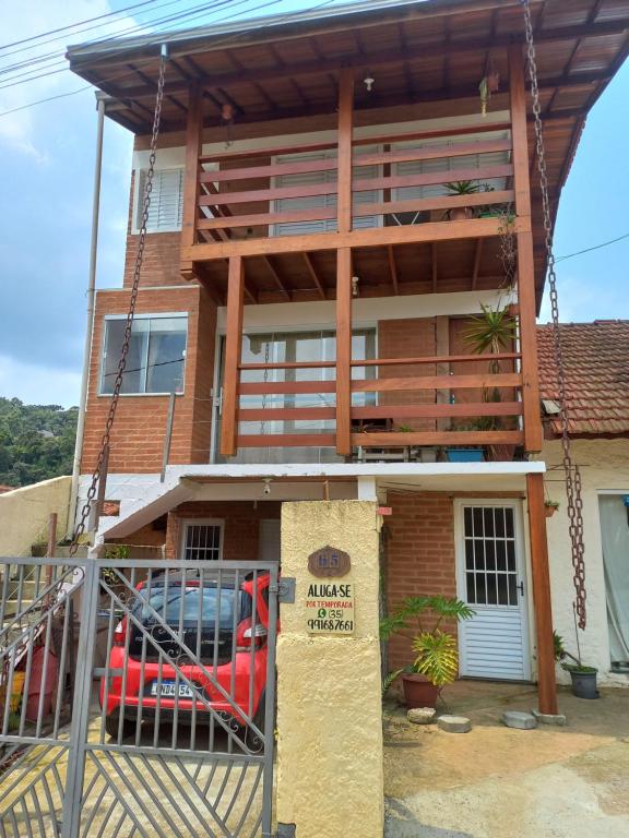 a house with a balcony on top of it at casa de temporada do Braz in Monte Verde