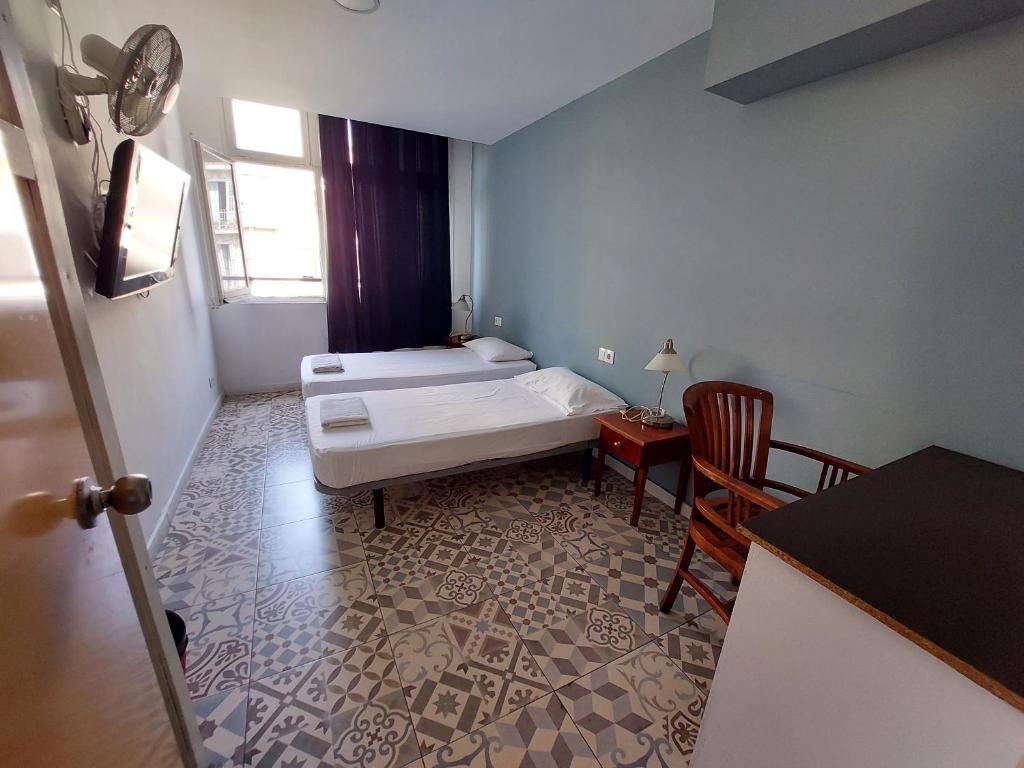 a bedroom with a bed and a table and chairs at Alberg Sants Bcn in Barcelona