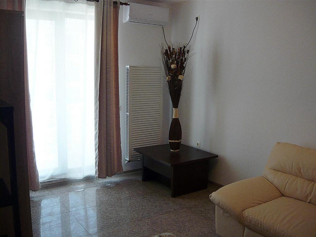 - un salon avec un vase sur une table et un canapé dans l'établissement Simona‘s apartment Mackerel, à Mamaia Nord – Năvodari