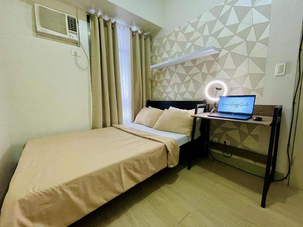 a bedroom with a bed with a laptop on a desk at Relaxing 2-Bed Apartment in Mandaluyong in Manila
