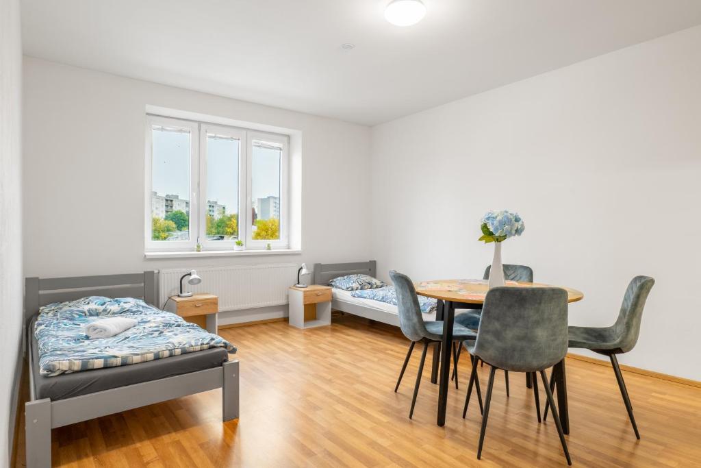 sala de estar con mesa, sillas y cama en Apartmány Borská Plzeň, en Plzeň