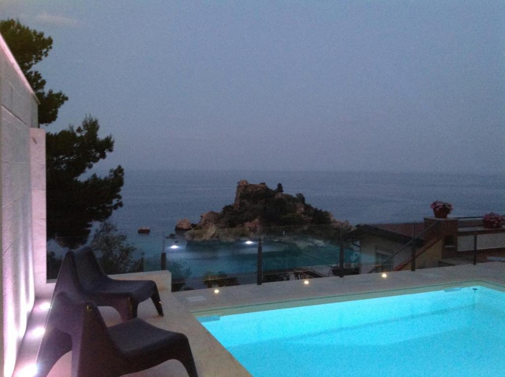 una piscina con vista sull'oceano di notte di 202 Luxury pool Isola Bella a Taormina