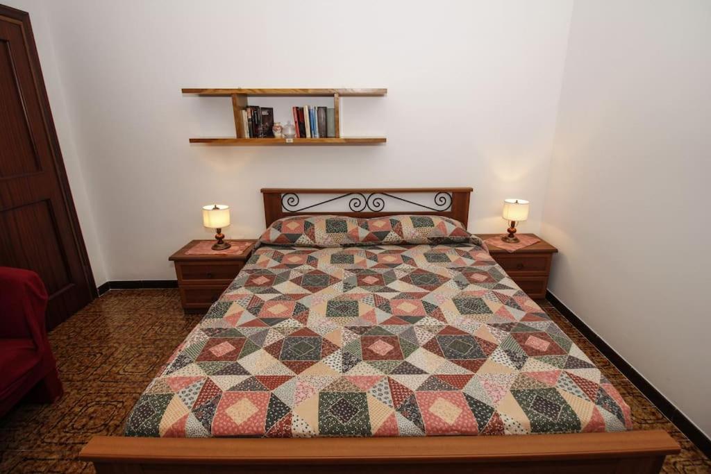 ein Schlafzimmer mit einem Bett mit zwei Nachttischen und zwei Lampen in der Unterkunft La casa di Carlo in SantʼAntìoco