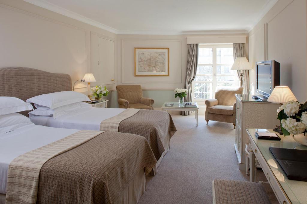 um quarto de hotel com duas camas e uma televisão em The Merrion Hotel em Dublin