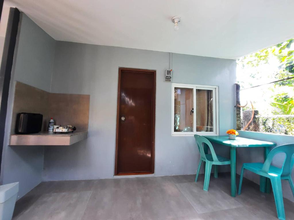 Habitación con mesa, sillas y ventana en Studio type unit - Host Homes Apitong en Tacloban