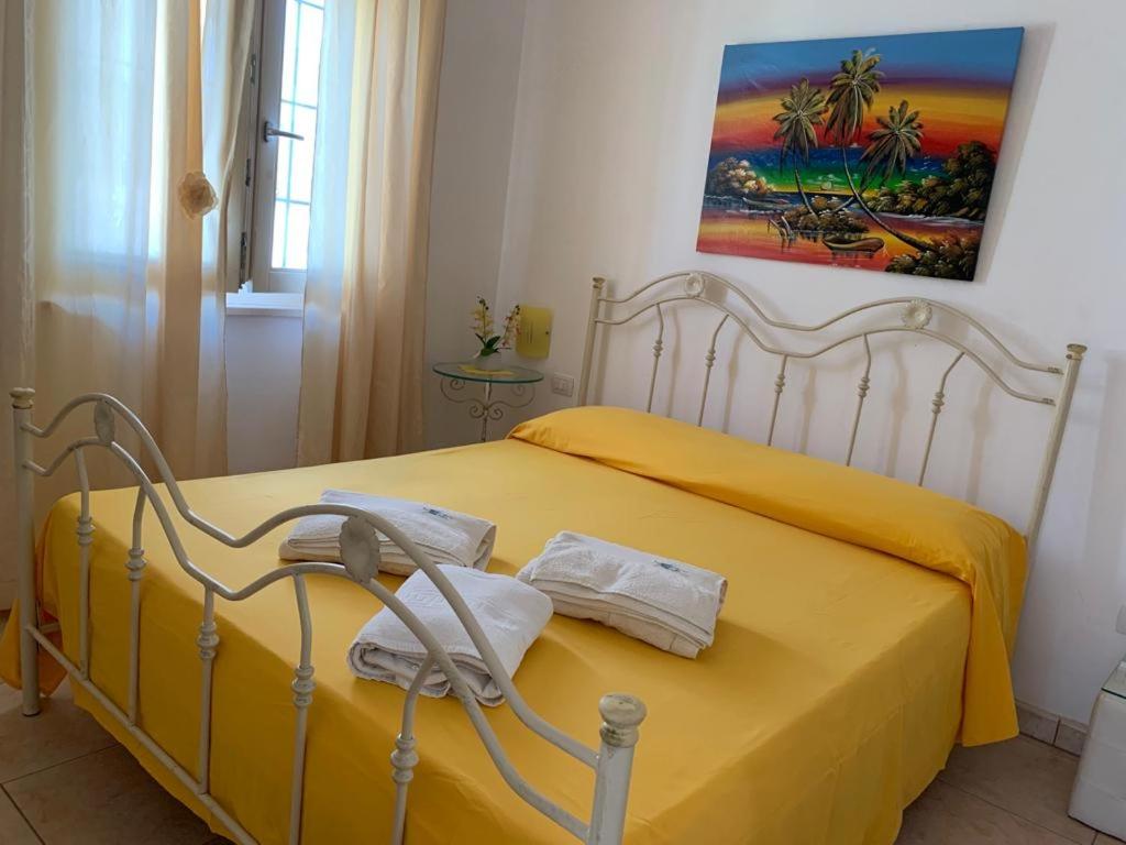 マリーナ・ディ・マンカヴェルサにあるcasasalentoholidays - BIlocale Fruttaのベッドルーム1室(黄色いベッド1台、タオル付)