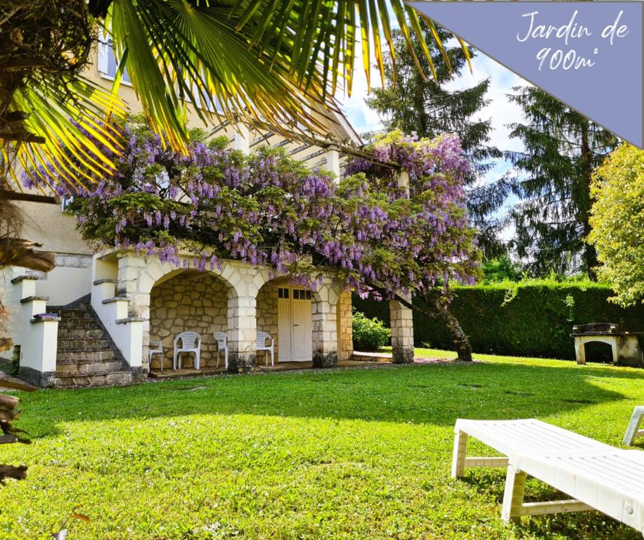 a house with a wreath of purple flowers on it at VILLA ANNEE 30 Rénovée ,Terrasse et Jardin in Souillac