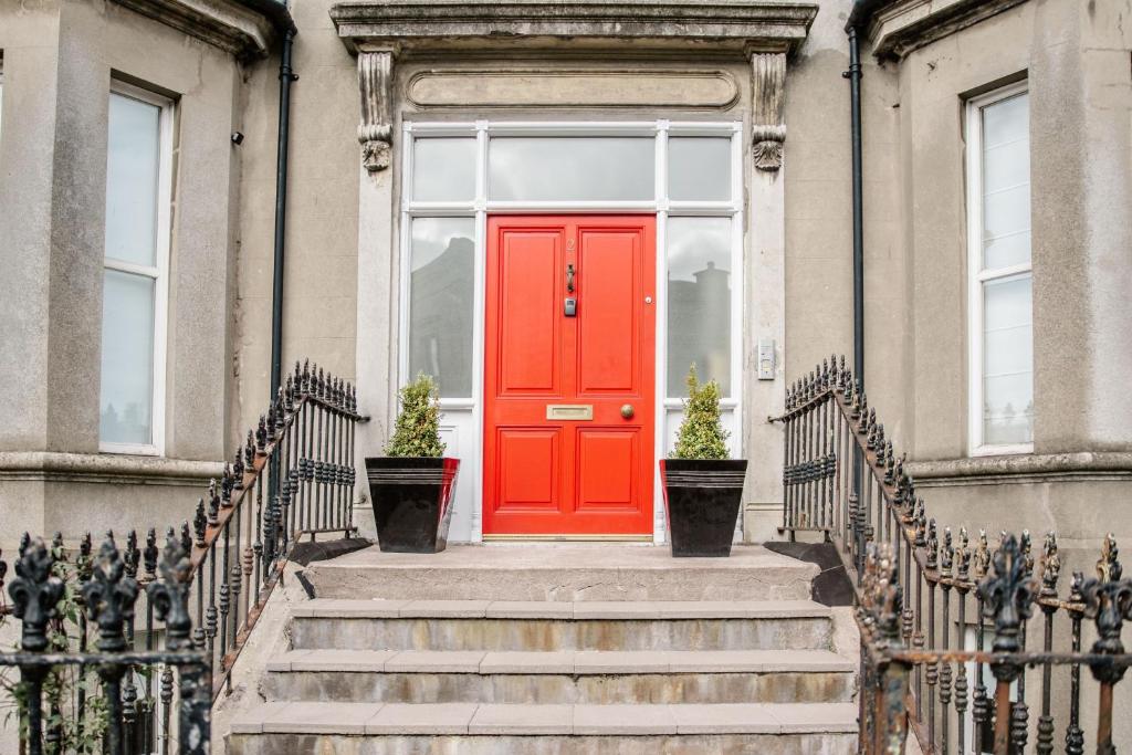 a red door on a building with stairs at Flat 4, 2 Victoria Street in Armagh
