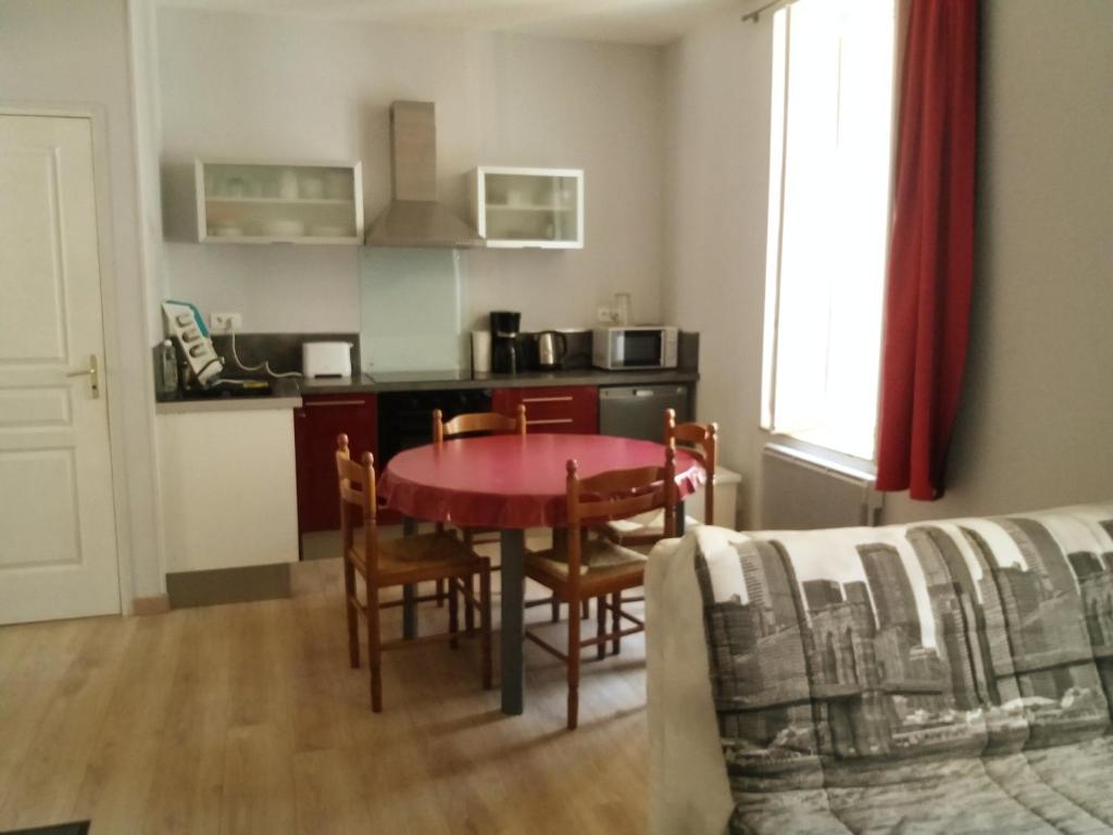 une cuisine et une salle à manger avec une table et des chaises dans l'établissement Appart résidence Le Dordogne, à La Bourboule