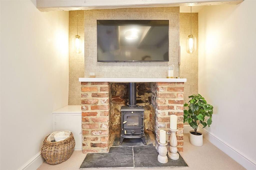 a brick fireplace with a television on top of it at Bridge Cottage in Yarm in Yarm