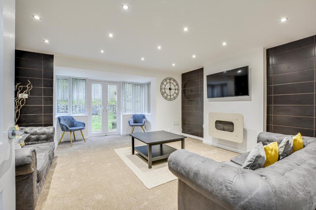 a living room with a couch and a tv at Elegant Bolton Abode - Sleeps 10 in Bolton