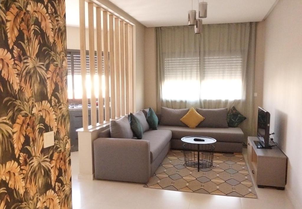 a living room with a couch and a table at Beautiful apartment next to airport Mohamed V in Derroua